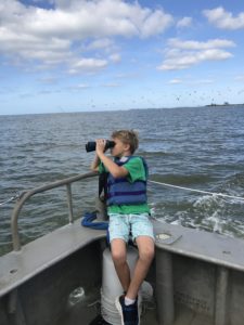 Child on boat looking through binoculars